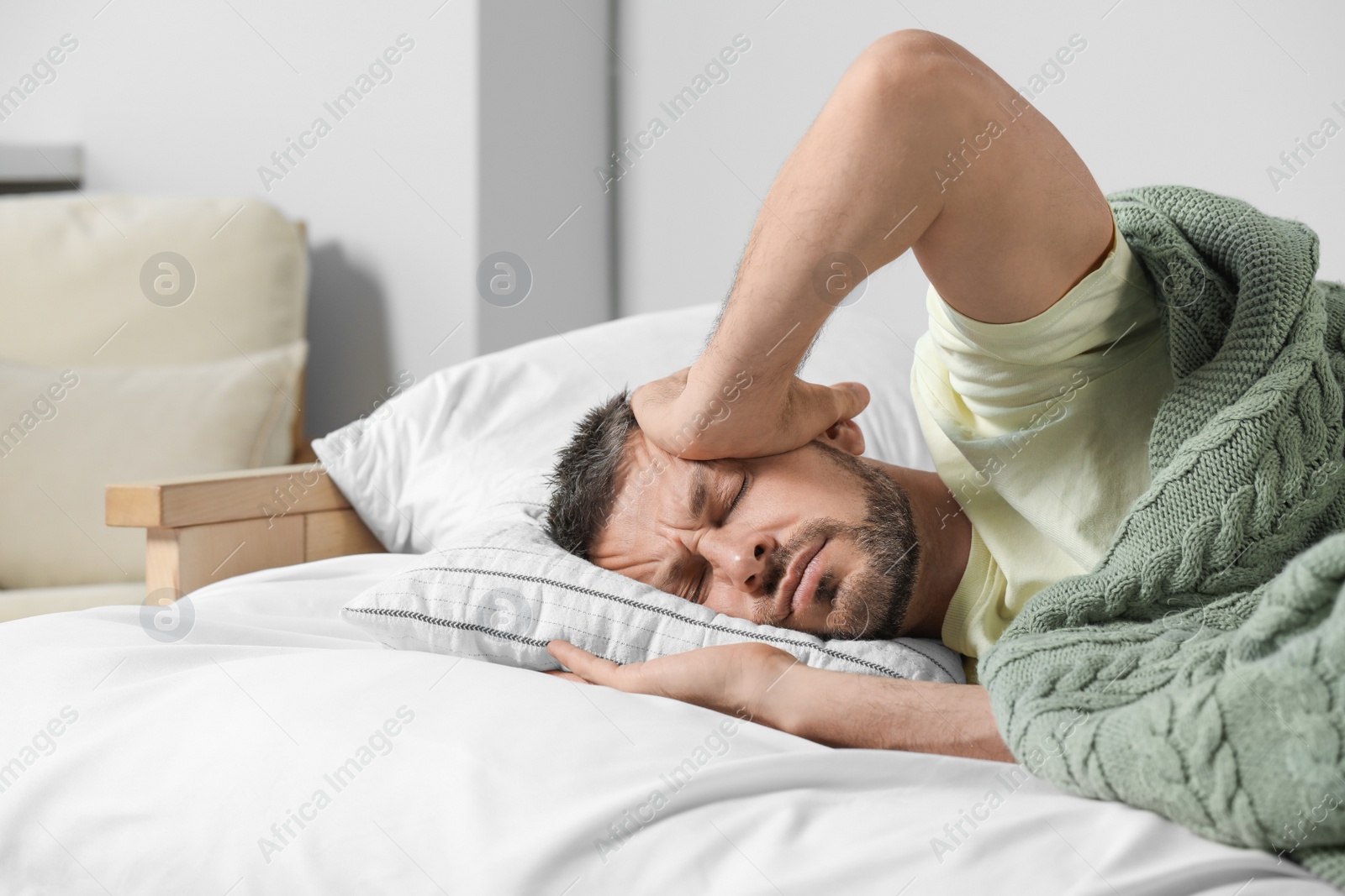 Photo of Sleepless man lying in bed at home