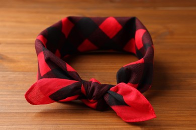 Photo of Tied red checkered bandana on wooden table