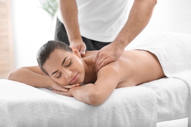 Photo of Relaxed woman receiving back massage in wellness center