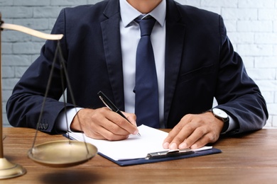 Photo of Male lawyer working with documents at table in office