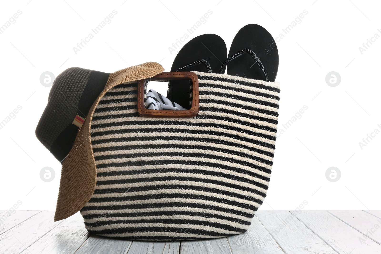 Photo of Set of beach accessories on wooden table, white background