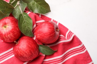 Fresh red apples with leaves on white table, flat lay. Space for text