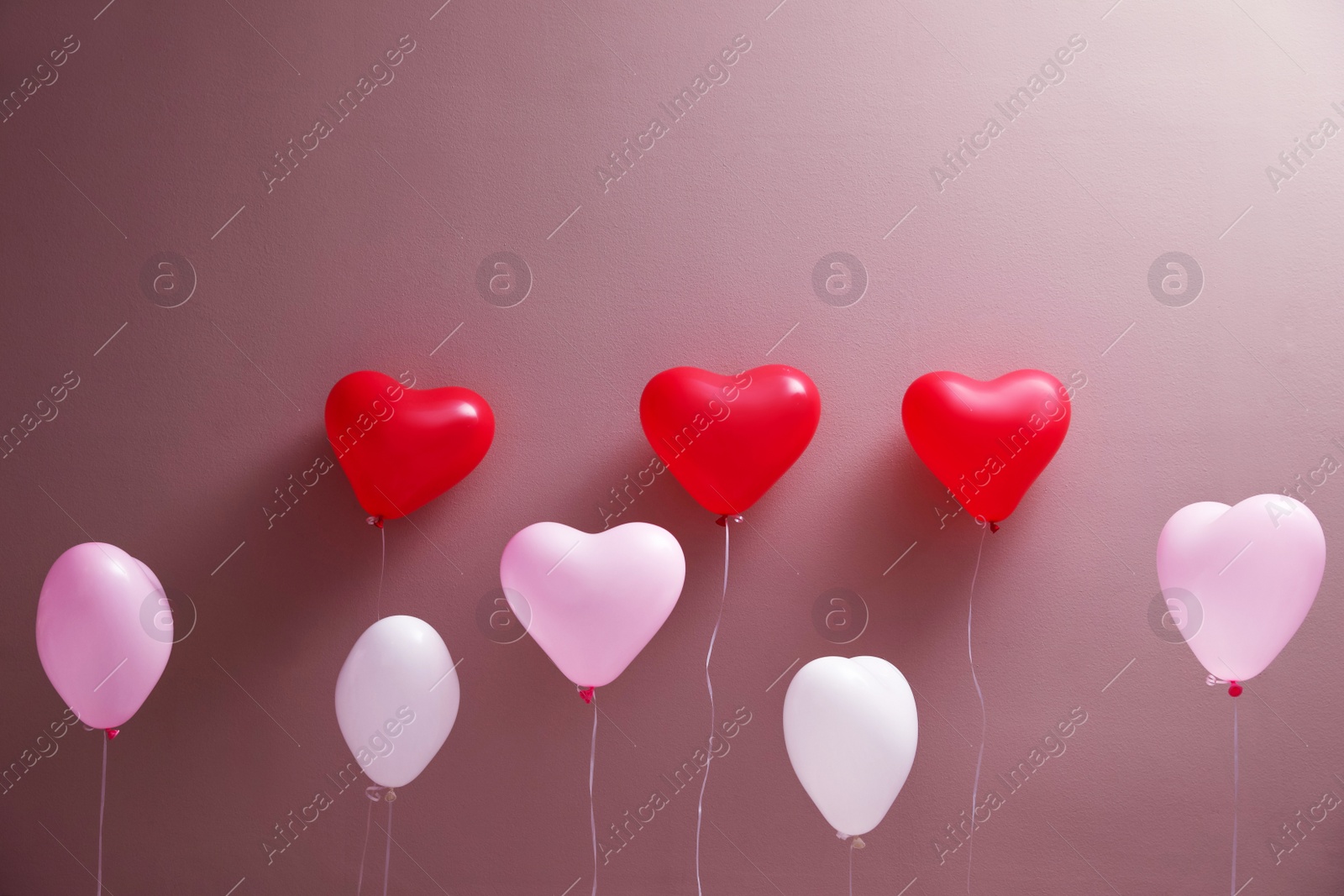 Photo of Colorful heart shaped balloons on brown background. Valentine's day celebration