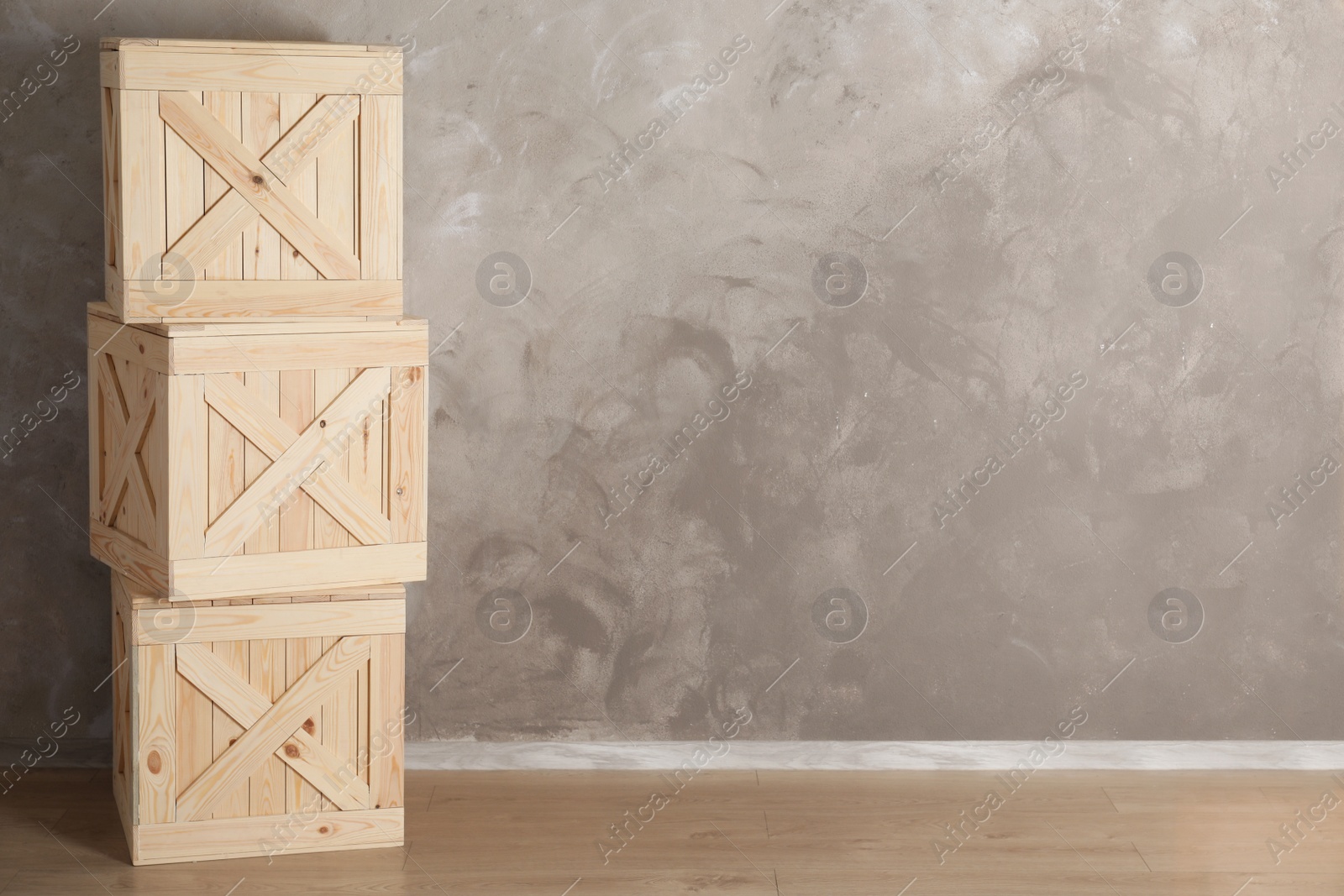 Photo of Wooden crates on floor against color background, space for text