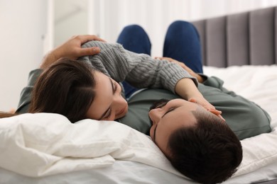 Affectionate young couple spending time together on bed