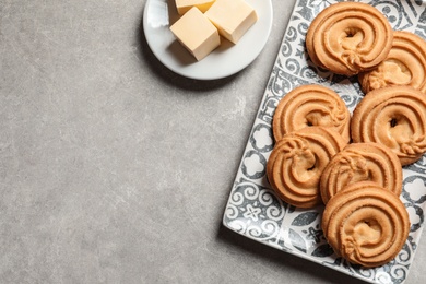 Plate with Danish butter cookies on grey background, top view