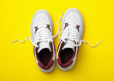 Photo of Pair of stylish shoes on yellow background, top view