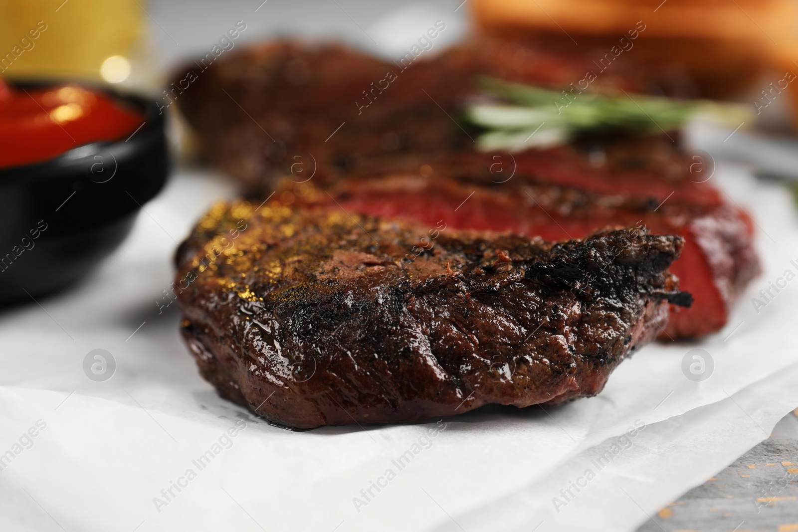 Photo of Delicious fried steak served on grey wooden table, closeup