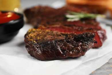 Delicious fried steak served on grey wooden table, closeup