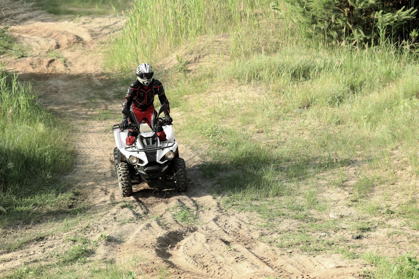 Photo of Man driving modern quad bike on sandy road. Extreme sport