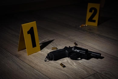 Gun and shell casings on wooden floor at crime scene