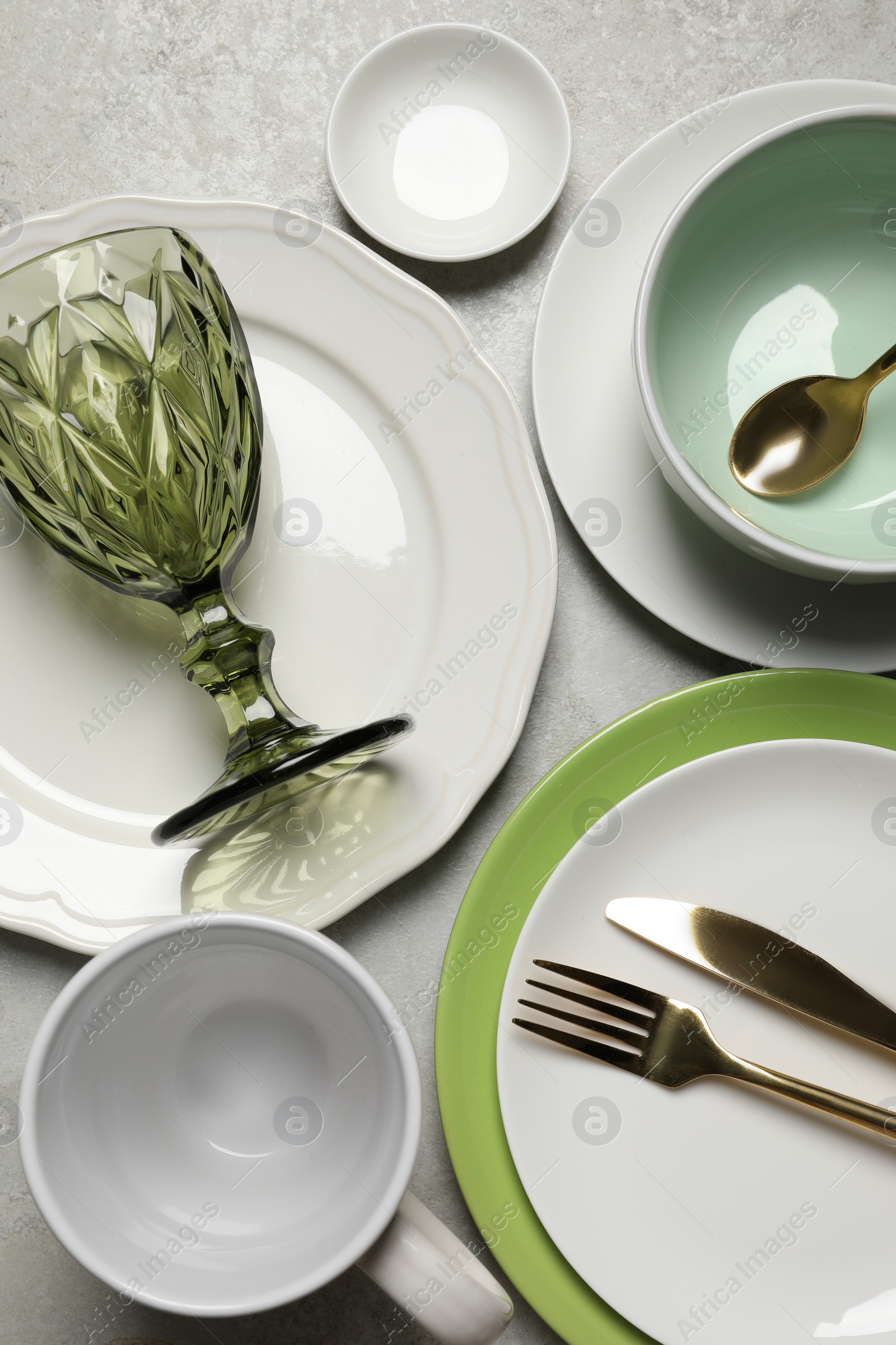 Photo of Beautiful ceramic dishware, cup, glass and cutlery on light grey table, flat lay