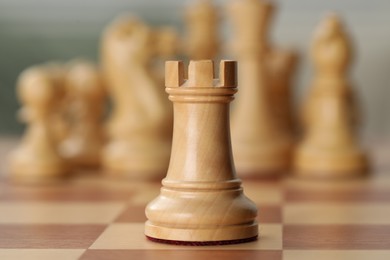 Photo of White wooden rook on chess board, closeup