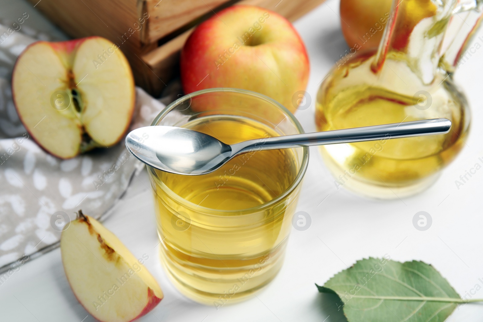 Photo of Natural apple vinegar and fresh fruits on white wooden table