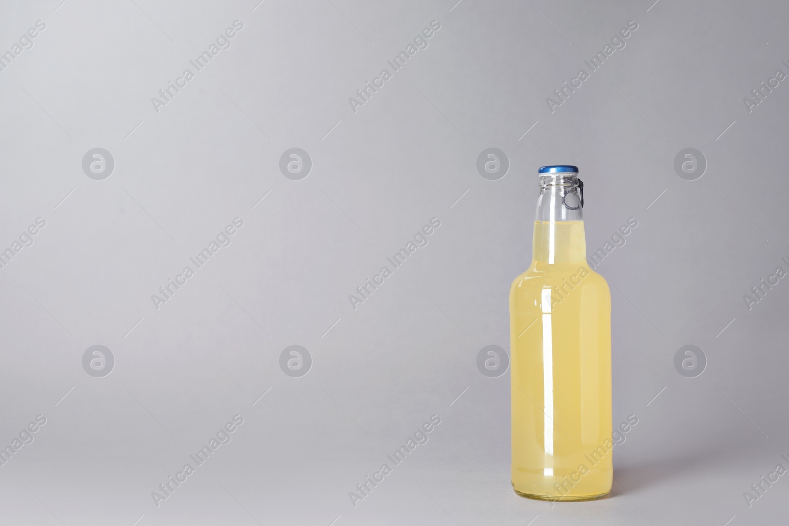 Photo of Bottle of alcoholic drink on grey background. Space for text