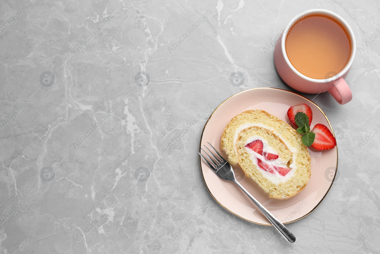 Photo of Slice of delicious sponge cake roll with strawberries and cream served on light grey table, flat lay. Space for text