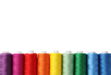 Different colorful sewing threads on white background, top view
