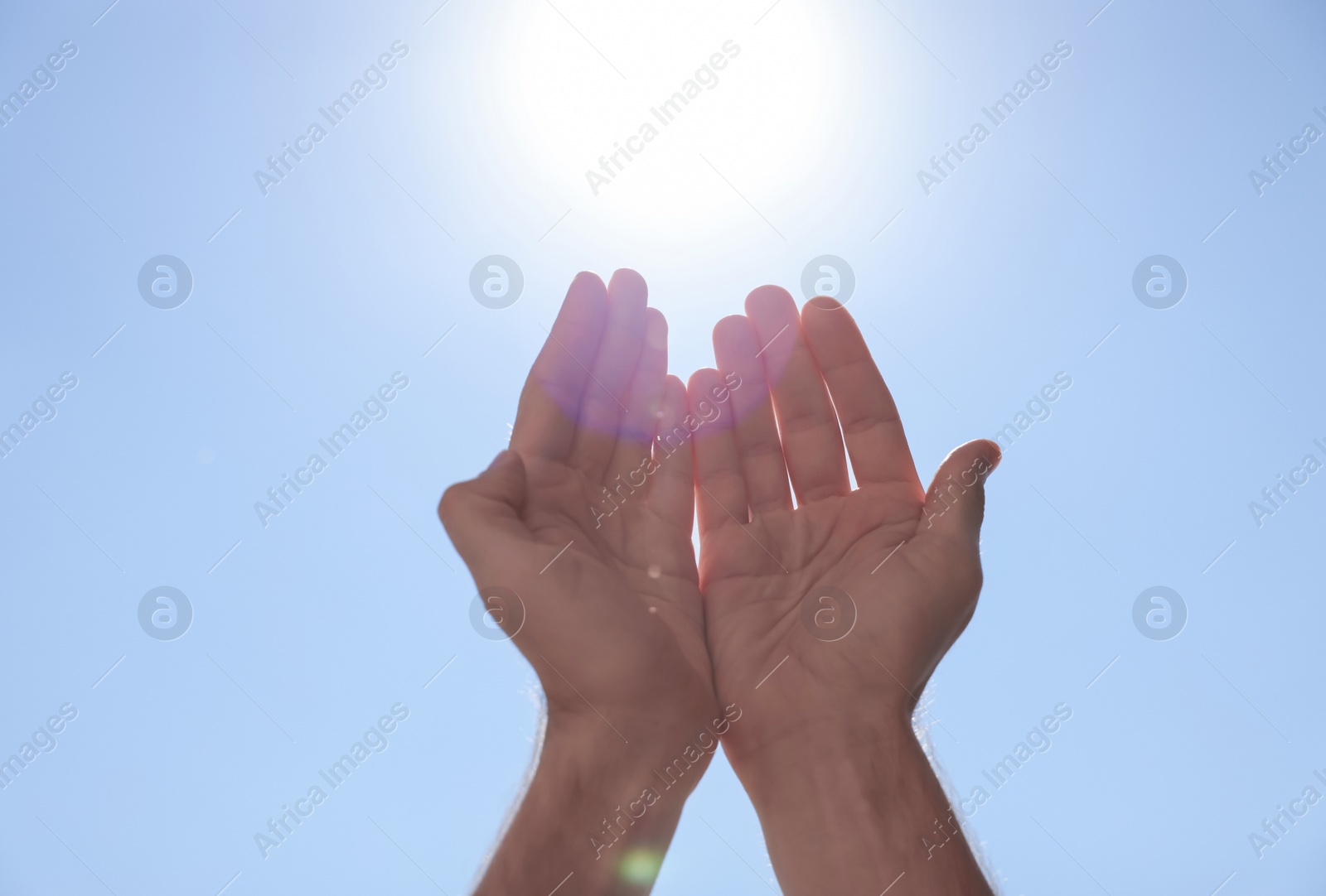Photo of Man reaching hands to blue sky outdoors on sunny day, closeup