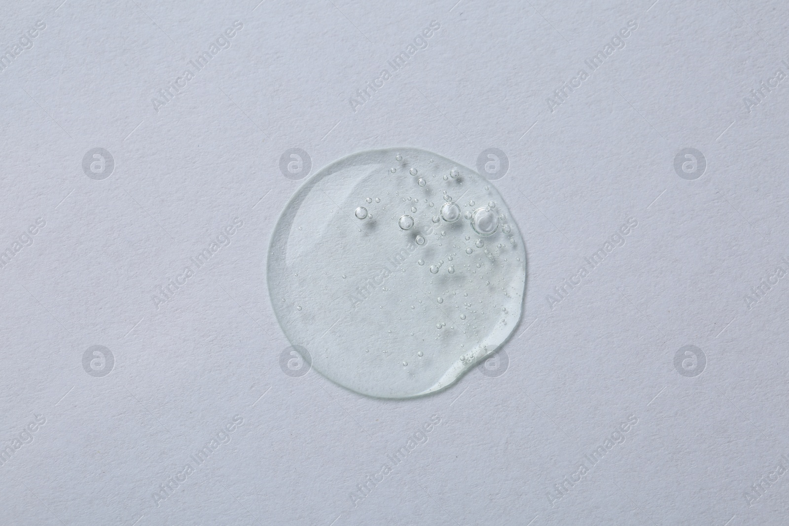 Photo of Sample of cosmetic serum on white background, top view