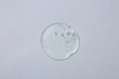 Photo of Sample of cosmetic serum on white background, top view