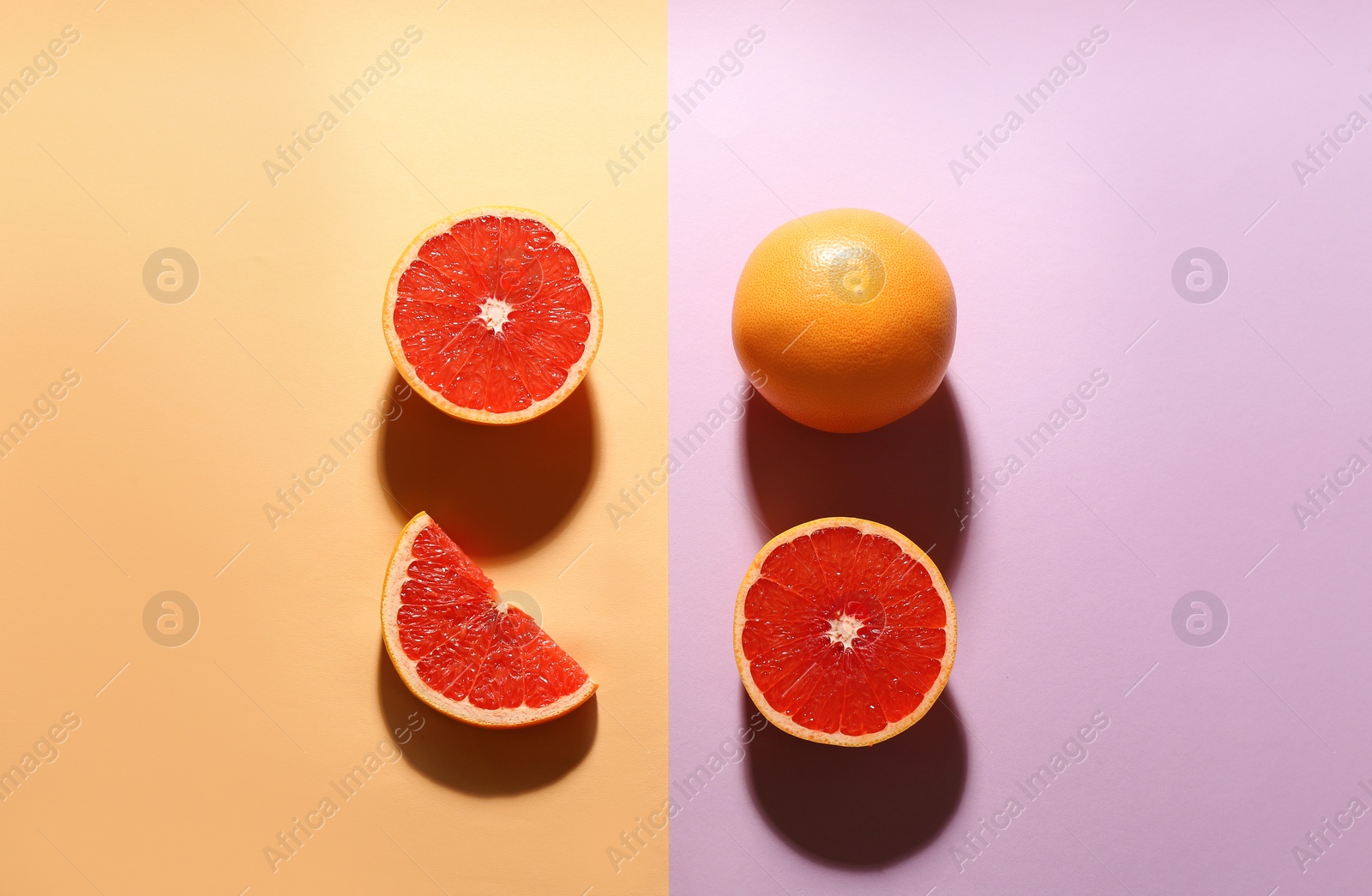 Photo of Cut and whole ripe grapefruits on color background, flat lay