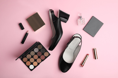 Photo of Stylish black female shoes and decorative cosmetics on pink background, flat lay