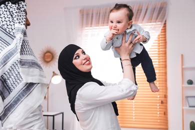 Photo of Happy Muslim family with little son at home