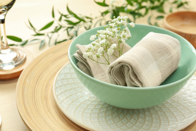 Elegant table setting with flowers and leaves, closeup