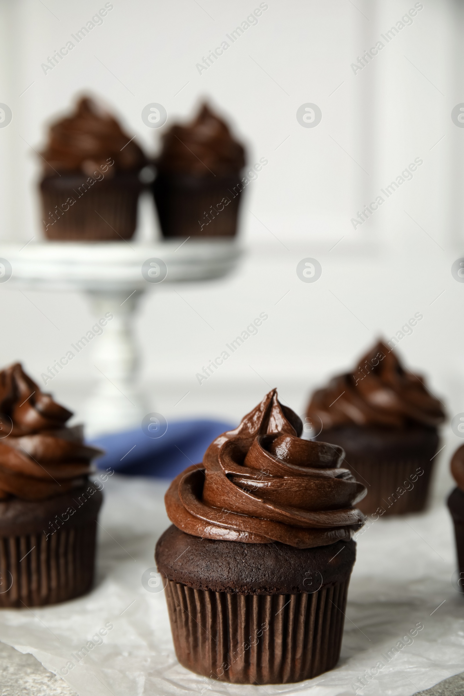 Photo of Delicious chocolate cupcake with cream on grey table. Space for text
