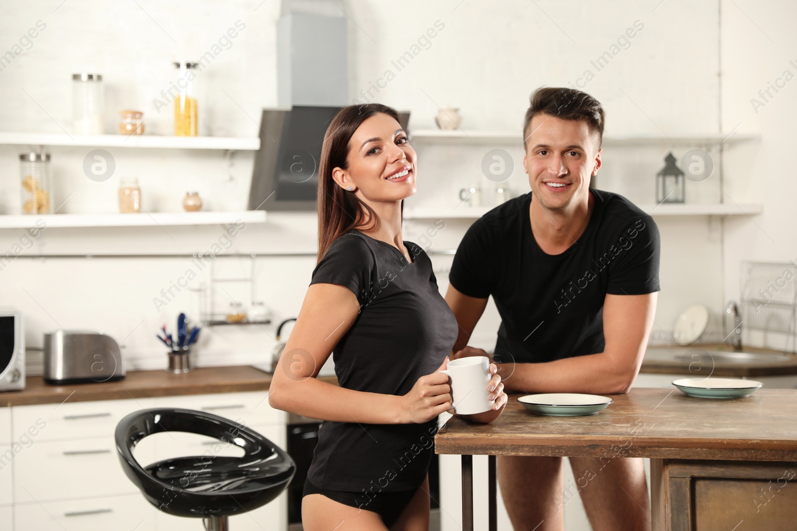 Photo of Happy couple wearing underwear in modern kitchen