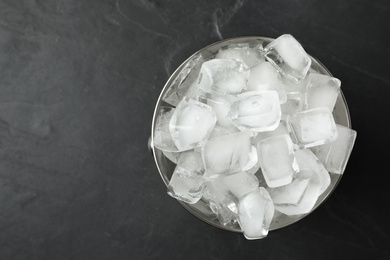 Metal bucket with ice cubes on grey background, top view. Space for text