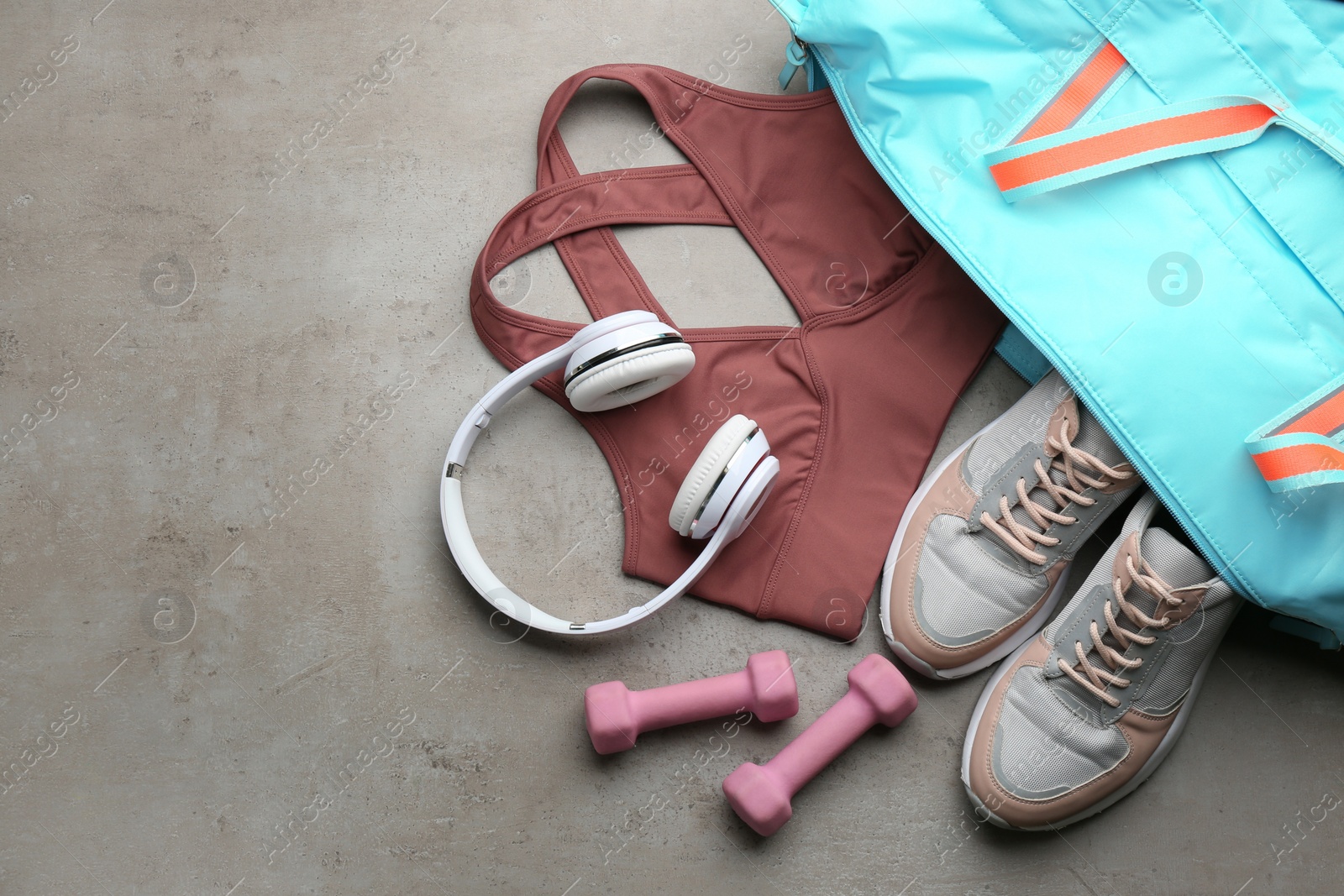 Photo of Flat lay composition with gym bag and sportswear on grey table