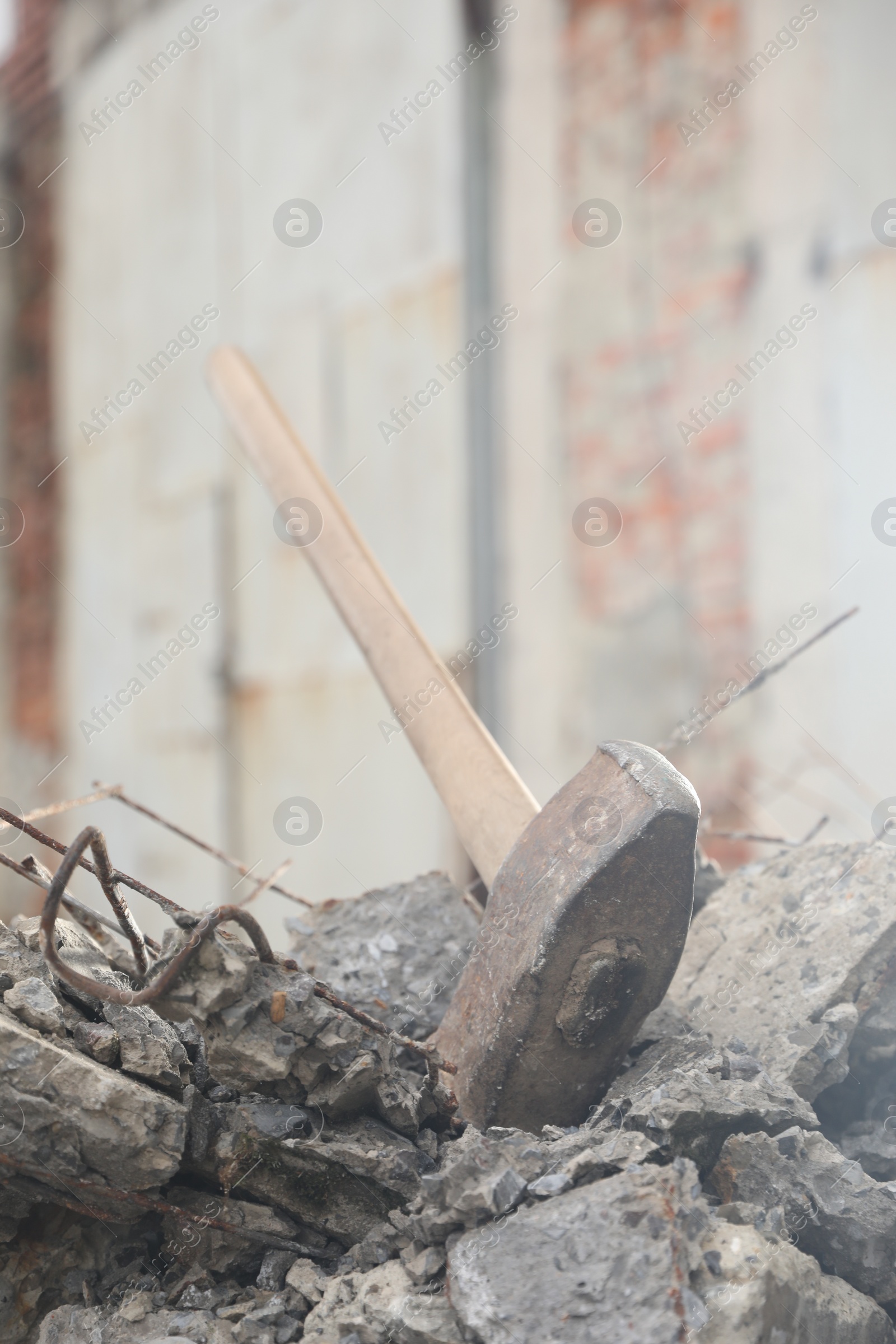 Photo of Sledgehammer on pile of broken stones outdoors