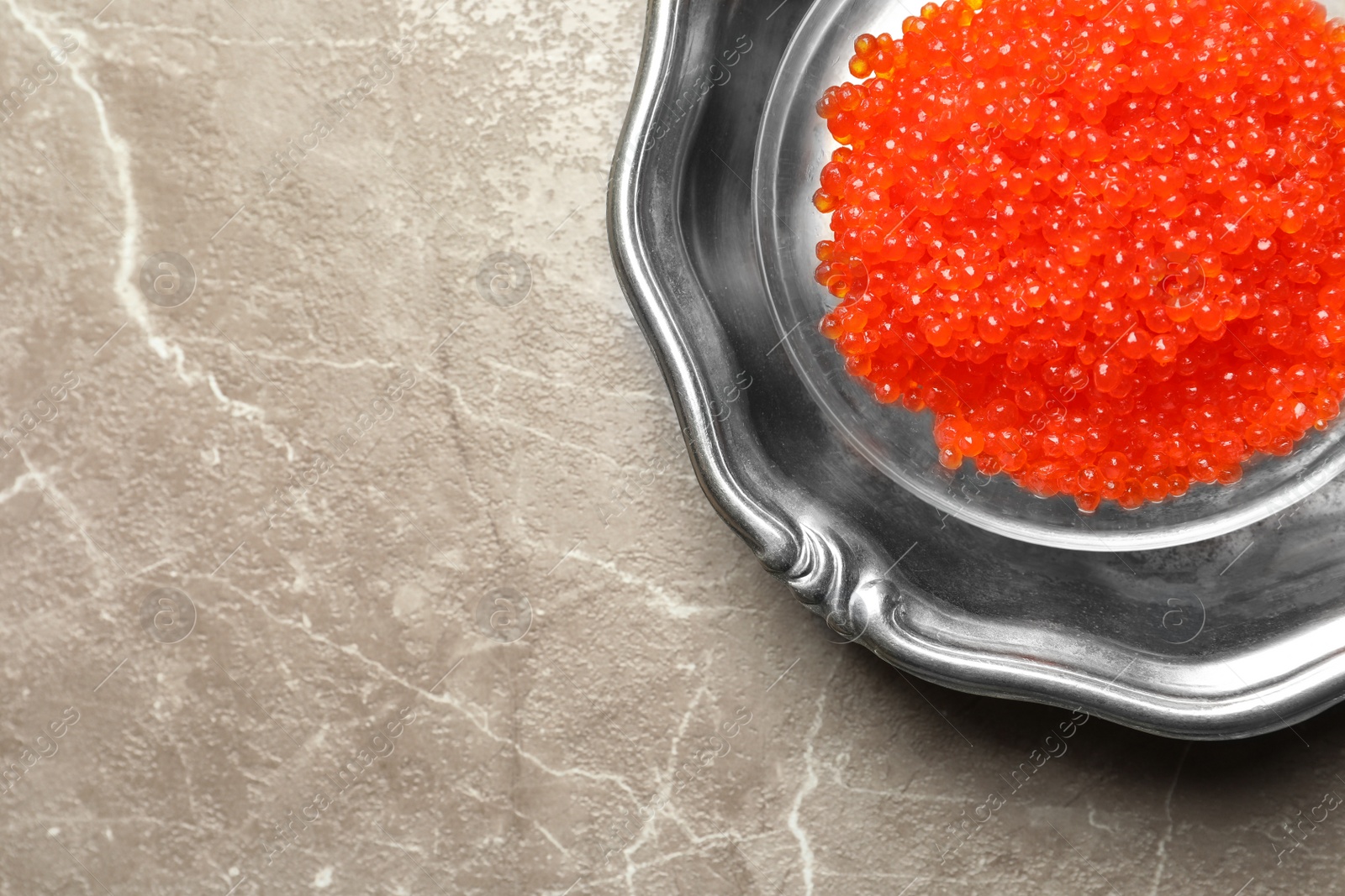 Photo of Dish with delicious red caviar on color background