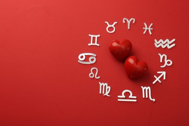 Zodiac signs and hearts on red background, flat lay. Space for text