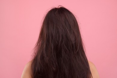 Photo of Woman with damaged hair on pink background, back view