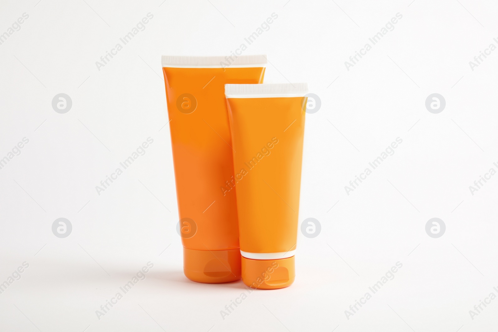 Photo of Tubes with sun protection body cream on white background