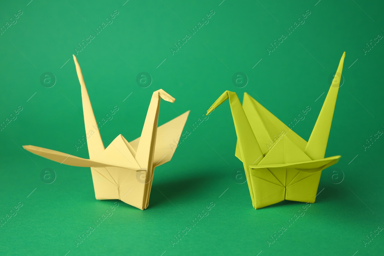 Photo of Colorful paper origami cranes on green background