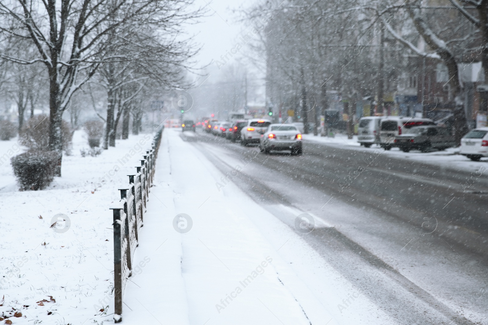Photo of City street with cars on snow storm day