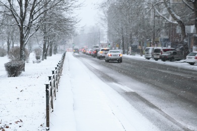 City street with cars on snow storm day