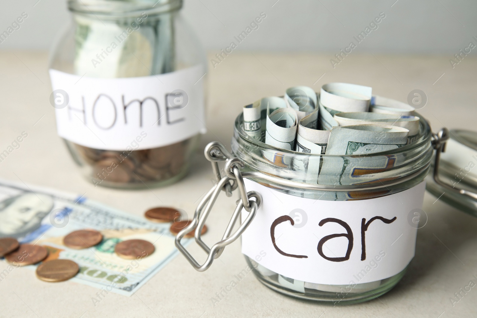 Photo of Glass jar with money and tag CAR on white table