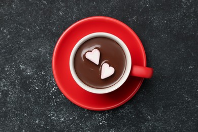 Photo of Cup of hot chocolate with heart shaped marshmallows on grey table, top view