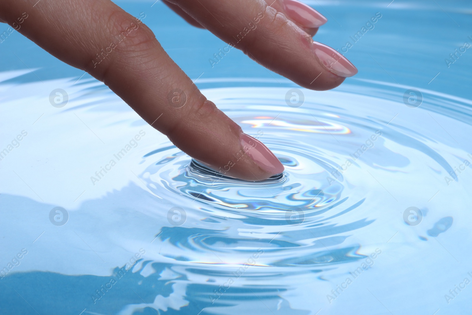 Photo of Woman touching clear water, closeup. Making ripples