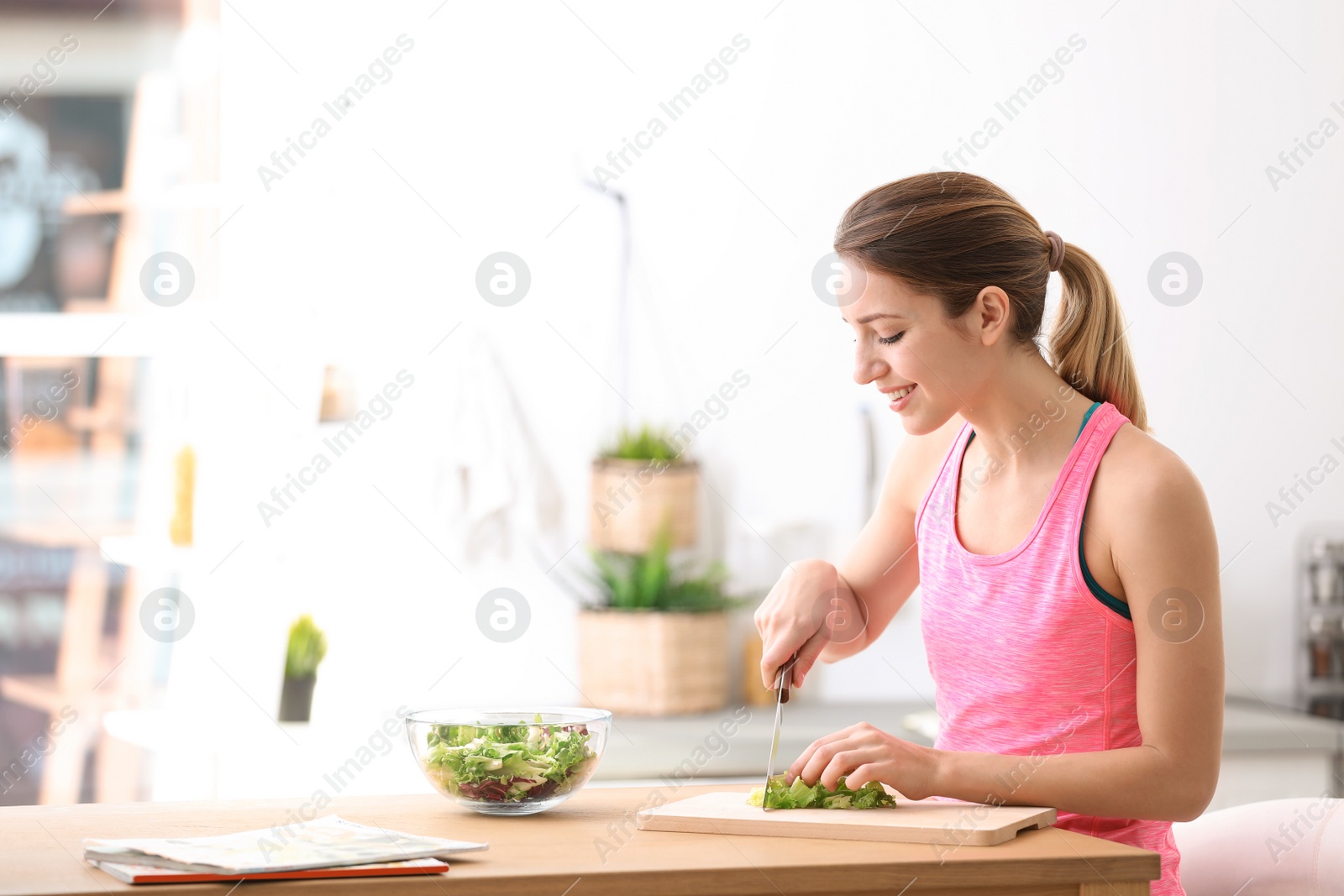 Photo of Young woman in fitness clothes preparing healthy breakfast at home. Space for text