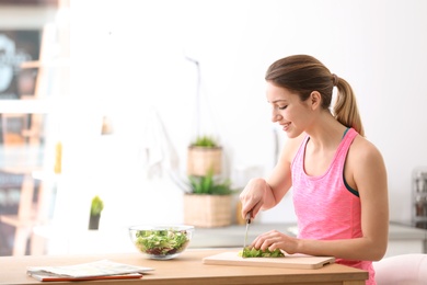 Young woman in fitness clothes preparing healthy breakfast at home. Space for text