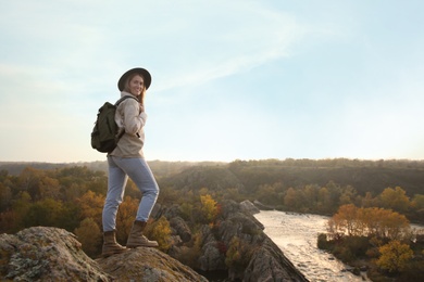 Photo of Woman with backpack enjoying beautiful view near mountain river