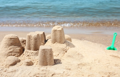 Photo of Little sand figures on beach near sea. Space for text