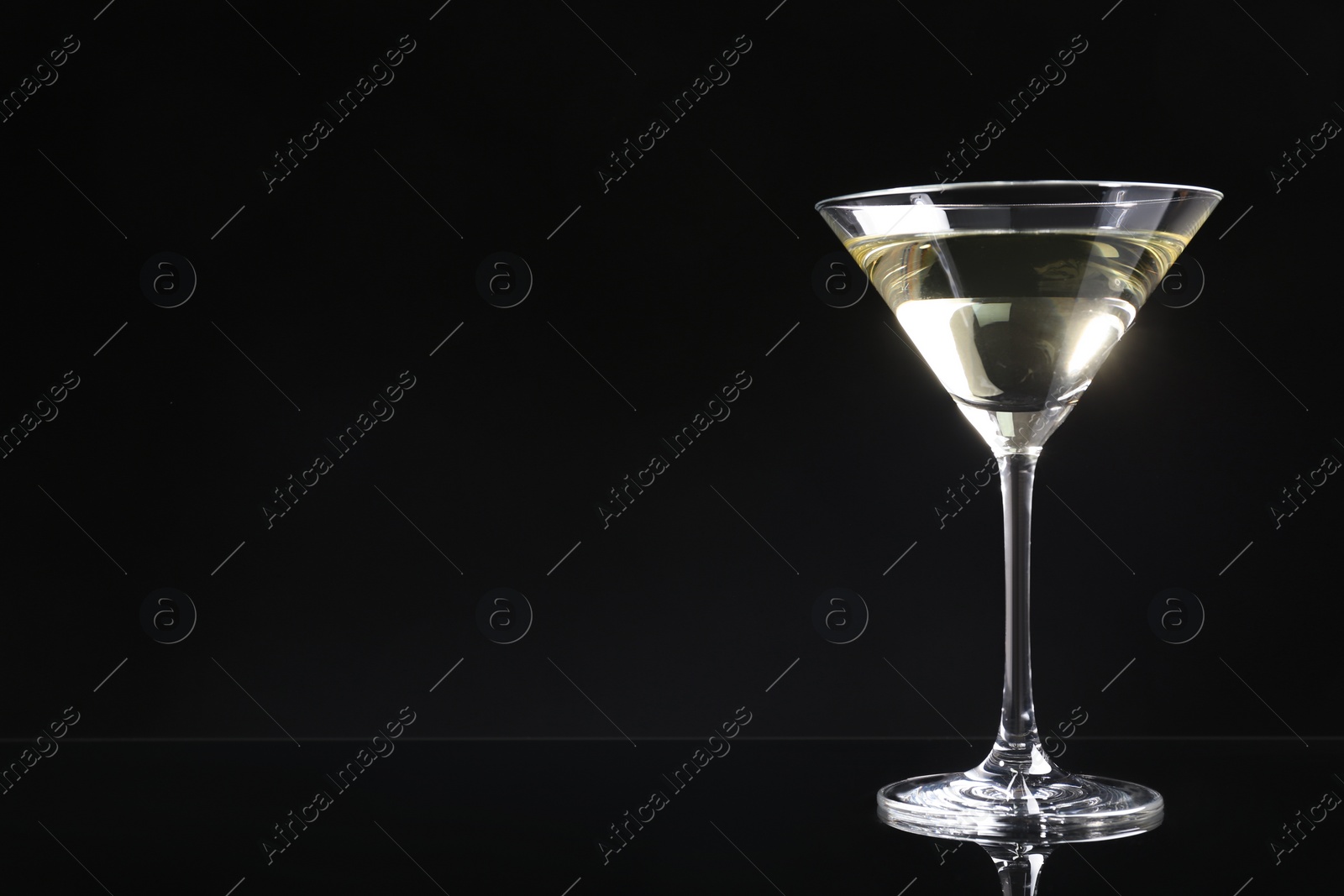 Photo of Martini cocktail on dark background. Space for text