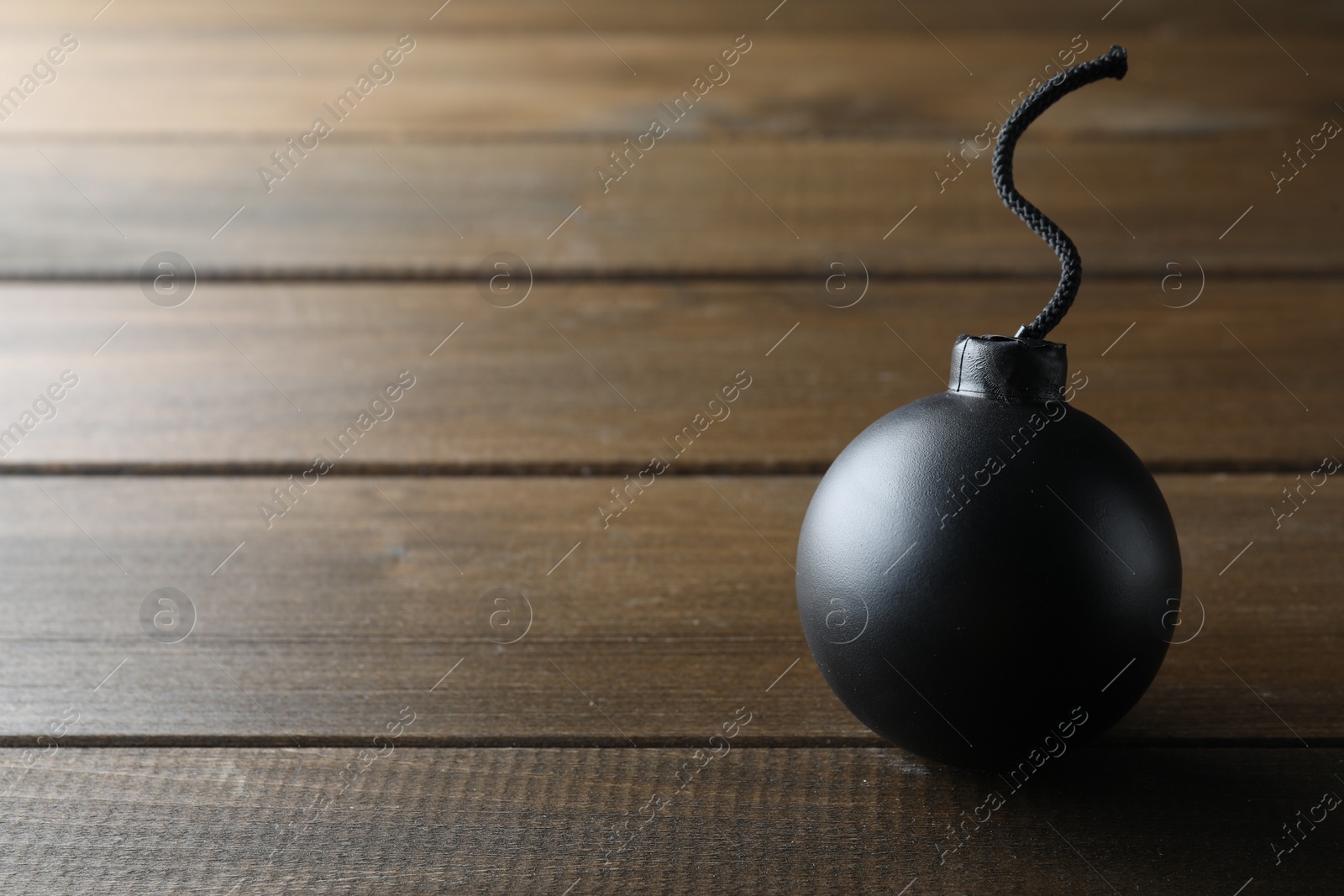 Photo of Old fashioned fuse bomb on wooden table. Space for text