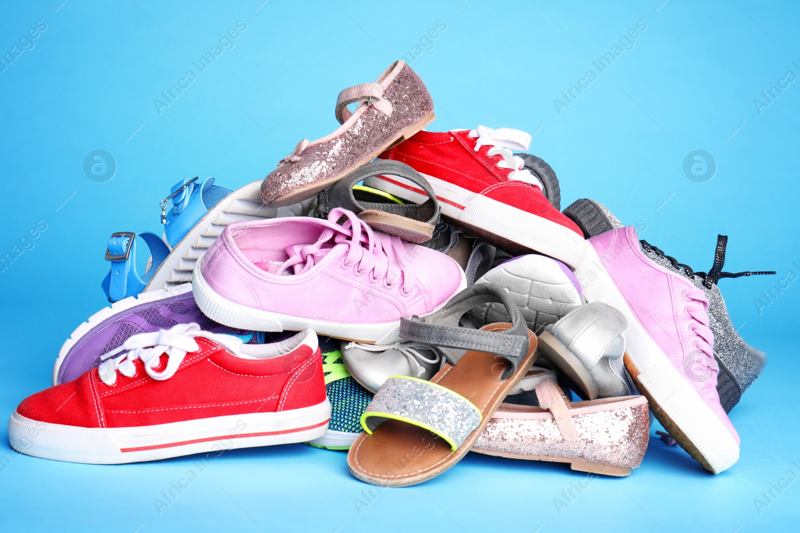 Photo of Heap of different shoes on color background